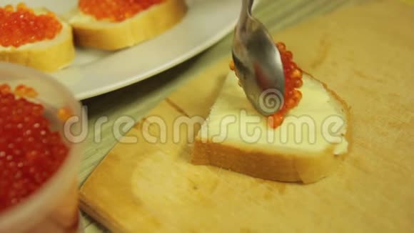 一位女士用黄油和红色鱼子酱涂抹罐头作为自助餐时间跨度视频的预览图