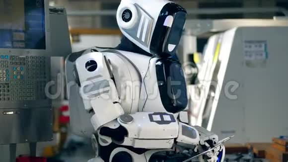 像人类一样的机器人正在工厂里操作平板电脑视频的预览图
