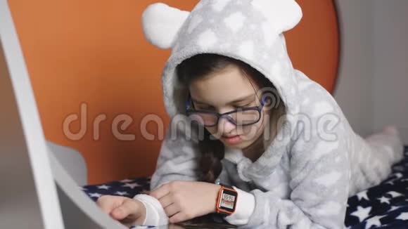 少女穿着温暖的睡衣看书躺在床上视频的预览图