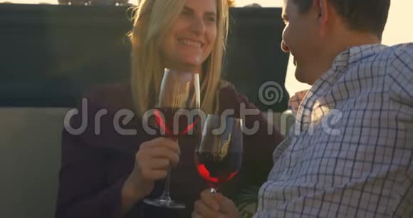 快乐的一对夫妻在家的阳台上喝红酒视频的预览图