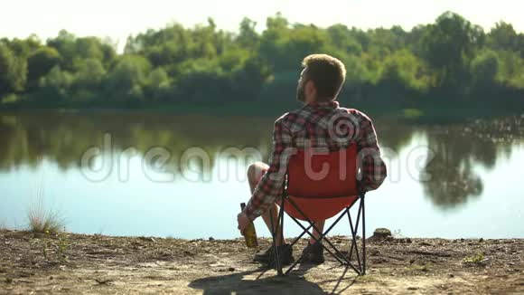 醉汉坐在河岸上欣赏风景休息度过周末视频的预览图