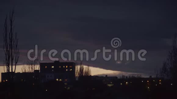 城市边缘房屋和树木后面的暮色和乌云视频的预览图