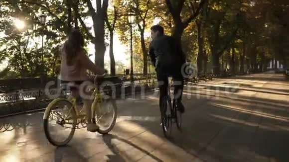 夏天在空旷的城市公园或林荫大道上难得看到一对年轻快乐的夫妇或朋友骑自行车视频的预览图