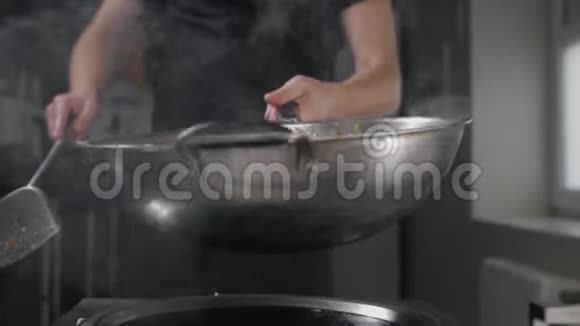 厨师用热锅炒菜慢动作煮亚洲面条在热锅里搅拌视频的预览图