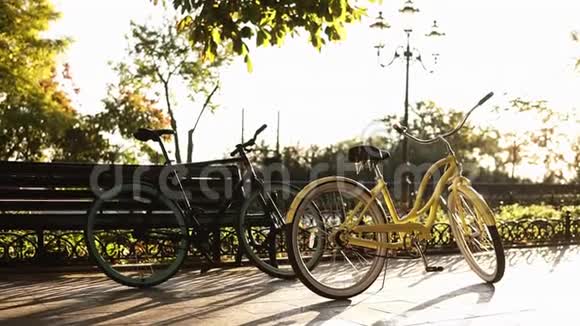 年轻夫妇穿着黑色便服的男人和穿着粉红色衣服的女人开始在夏季城市公园骑自行车视频的预览图