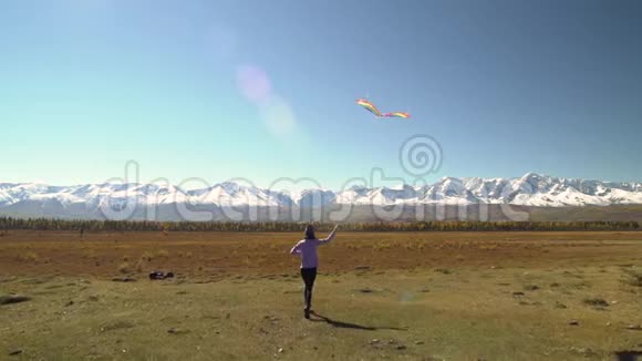 女孩带着风筝在山上到处跑自由概念视频的预览图