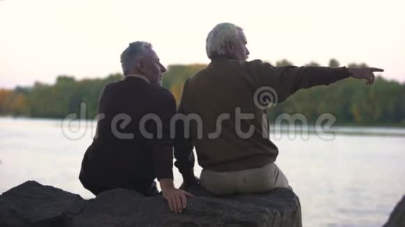 两个退休的男人周末在河边看风景视频的预览图