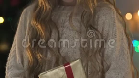可爱的女孩拿着圣诞礼物对着镜头微笑快乐的童年特写视频的预览图