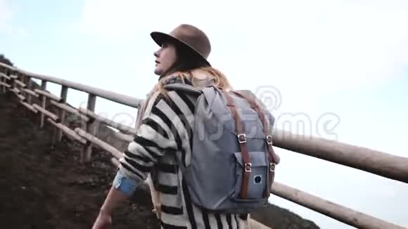 年轻时尚的旅游女性背着背包徒步旅行前往意大利维苏威火山顶部度假视频的预览图