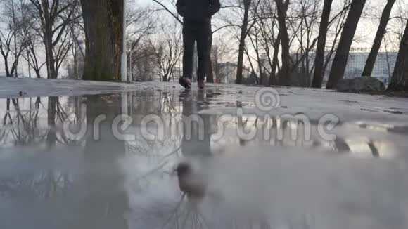 一个人踏着融化的雪走在春天视频的预览图