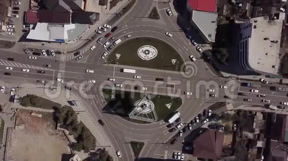 在带有交通车的城市道路上放大从上往下看环形交叉路口视频的预览图