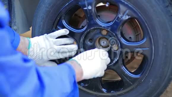 男机修工的手把轮胎放在车轴上拧紧螺母视频的预览图