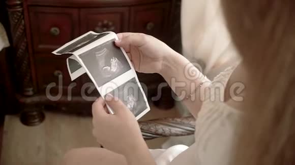 孕妇在沙发上看婴儿的超声波扫描视频的预览图