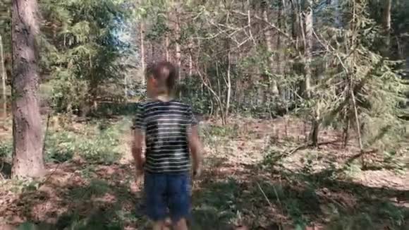 无法辨认的7岁男孩正在山上的森林里徒步旅行后景慢动作视频的预览图