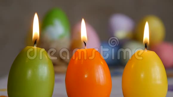 用复活节彩蛋做成的蜡烛蜡烛从空中熄灭绿色橙色黄色复活节彩蛋蜡烛和蜡烛视频的预览图