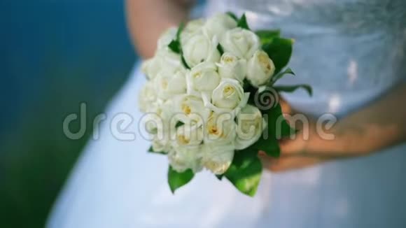 新娘手里拿着一大束漂亮的结婚花束抚摸着花束里的花用手指抚摸着视频的预览图