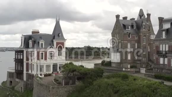 夏季在灰色的多云天气下在法国河滨上空俯瞰风景如画的中世纪石楼视频的预览图