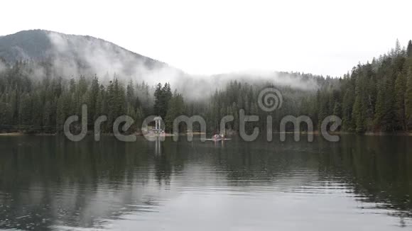 多雨的雾天在塞尼弗湖上那里漂浮着一只筏子和游客视频的预览图