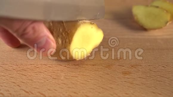 一个人用刀子把一根多汁的姜根切成碎片视频的预览图