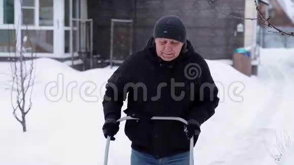 冬季和清洁概念成熟的人从车道上铲雪视频的预览图