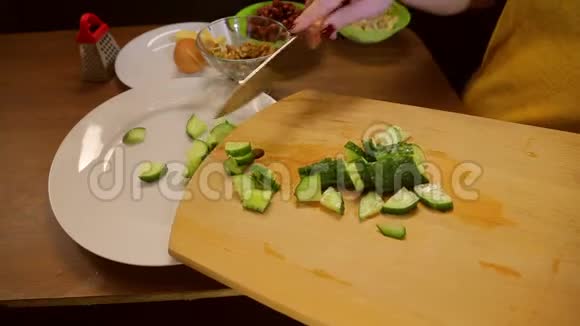 一个拿着刀的女人把黄瓜变成了一个白色的盘子视频的预览图