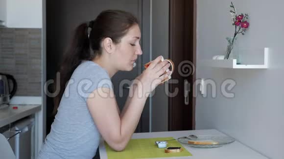 年轻的女旅行者正在酒店房间里吃早餐视频的预览图