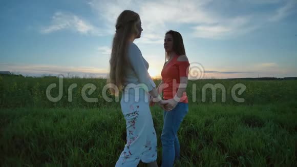 朋友们玩得开心晚上在田野里牵着手落在草地上视频的预览图