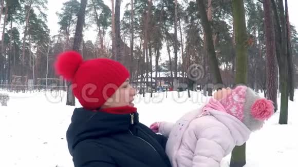 妈妈把女儿抱在冬天的森林里视频的预览图