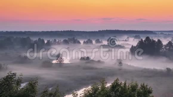 神奇的日出越过薄雾景观雾状的早晨天空太阳升起在薄雾森林和河流之上视频的预览图