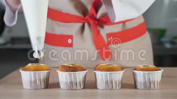 糕点厨师用纸杯装饰纸杯蛋糕白色奶油和糕点袋视频的预览图