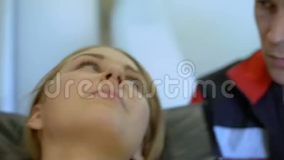 年轻医生支持躺在救护车担架上的女孩照顾病人视频的预览图