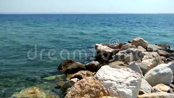 希腊尼基蒂哈尔基迪基地区有岩石和水晶水的海滩视频的预览图