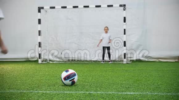 孩子们踢足球一个小孩踢球但是看门人保护大门视频的预览图