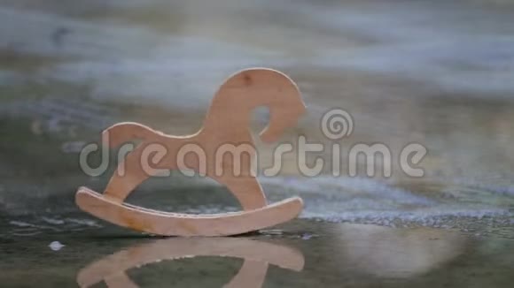 木制玩具马在雨中的水坑里视频的预览图