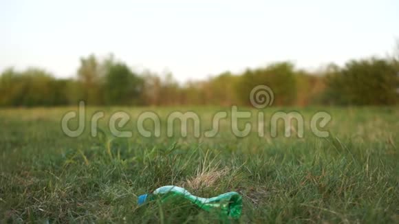 戴着蓝色橡胶手套的女性从草地上捡起一个塑料瓶停止塑料概念环保视频的预览图