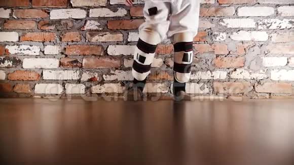 一个穿着空手道服的小女孩吐着腿热身运动视频的预览图