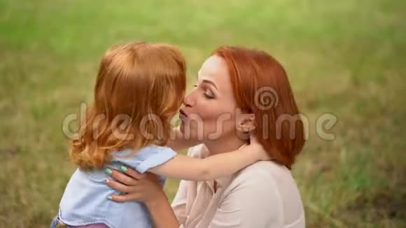 美丽的母亲在户外亲吻她的孩子视频的预览图
