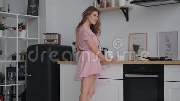 快乐无忧无虑的女孩在厨房里跳舞准备早餐视频的预览图