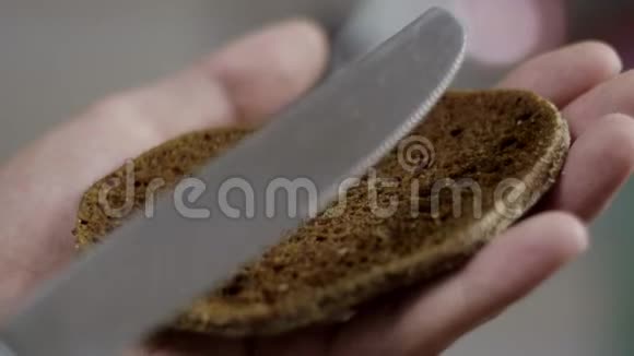 人们手缓慢地在厨房的棕色面包片上撒黄油视频的预览图