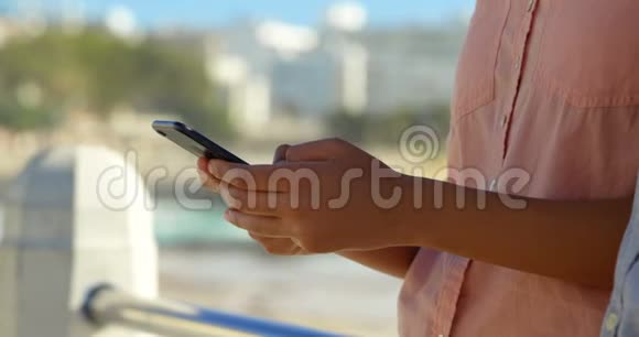 4k栏杆附近使用手机的妇女特写视频的预览图