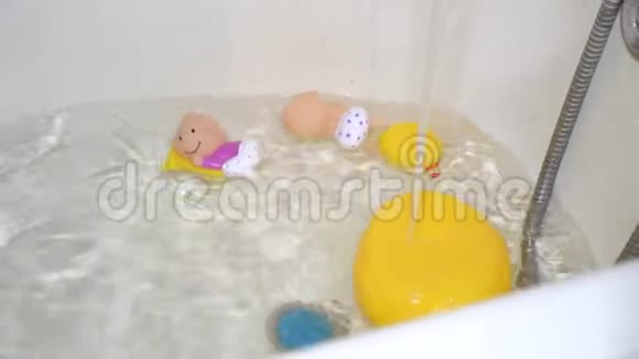 在孩子们洗澡时玩具从水龙头里抽出干净的水来给婴儿洗澡视频的预览图