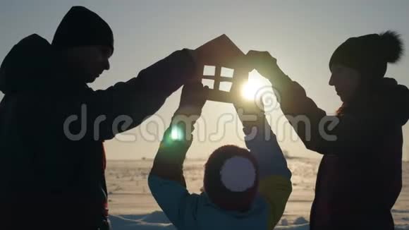 一家人在日落时分抱着纸房梦见自己的家日落时分手中的纸房剪影视频的预览图