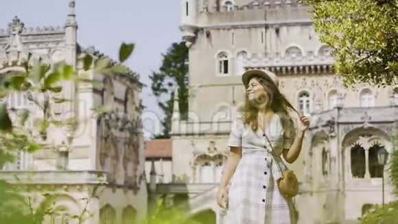 快乐的年轻女子走在宫廷花园里视频的预览图