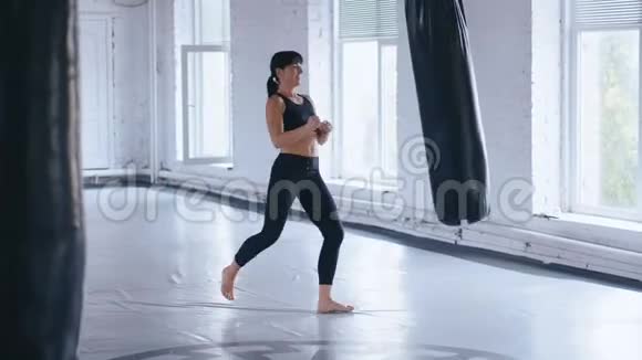 拳击职业运动员女子在健身房踢拳袋跆拳道女子体操训练视频的预览图