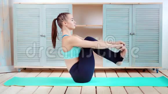 运动的女人美丽的形状显示完美的伸展用手握腿全镜头视频的预览图
