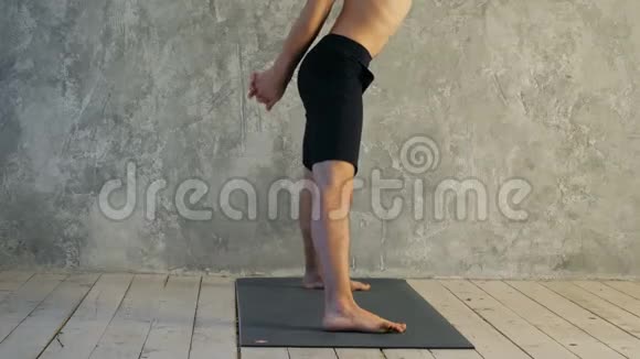 运动型肌肉型青年瑜伽男做宽幅向前弯曲普拉萨里塔帕多塔纳萨纳姿势视频的预览图