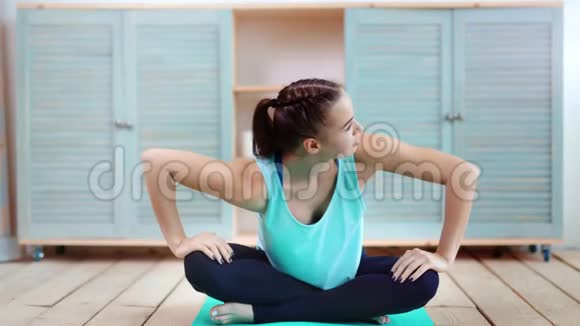 年轻的普拉提女士坐在垫子上在健身房训练后伸展身体双手放在腿上全镜头视频的预览图