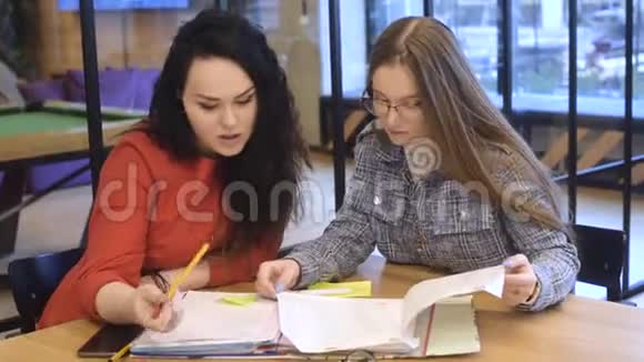 一个学生帮助另一个学生做作业解释课程外语教师办公室工人讨论合同视频的预览图