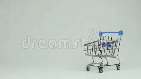 男人手把粉色礼物复活节彩蛋放在一个白色背景的购物篮里复制空间概念超市视频的预览图