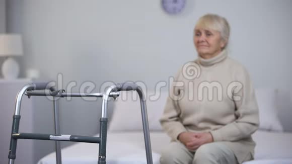 老年妇女坐在行走架附近关节手术后残疾视频的预览图